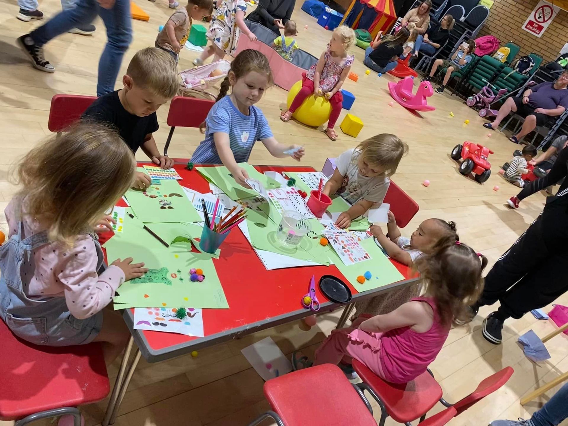 A group of children are sitting at a table in a room.