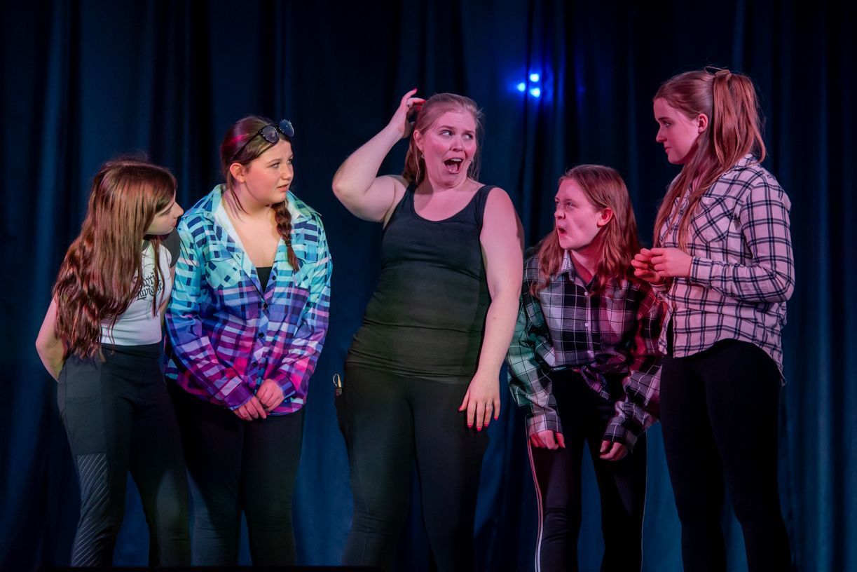 A group of young girls are standing next to each other on a stage.