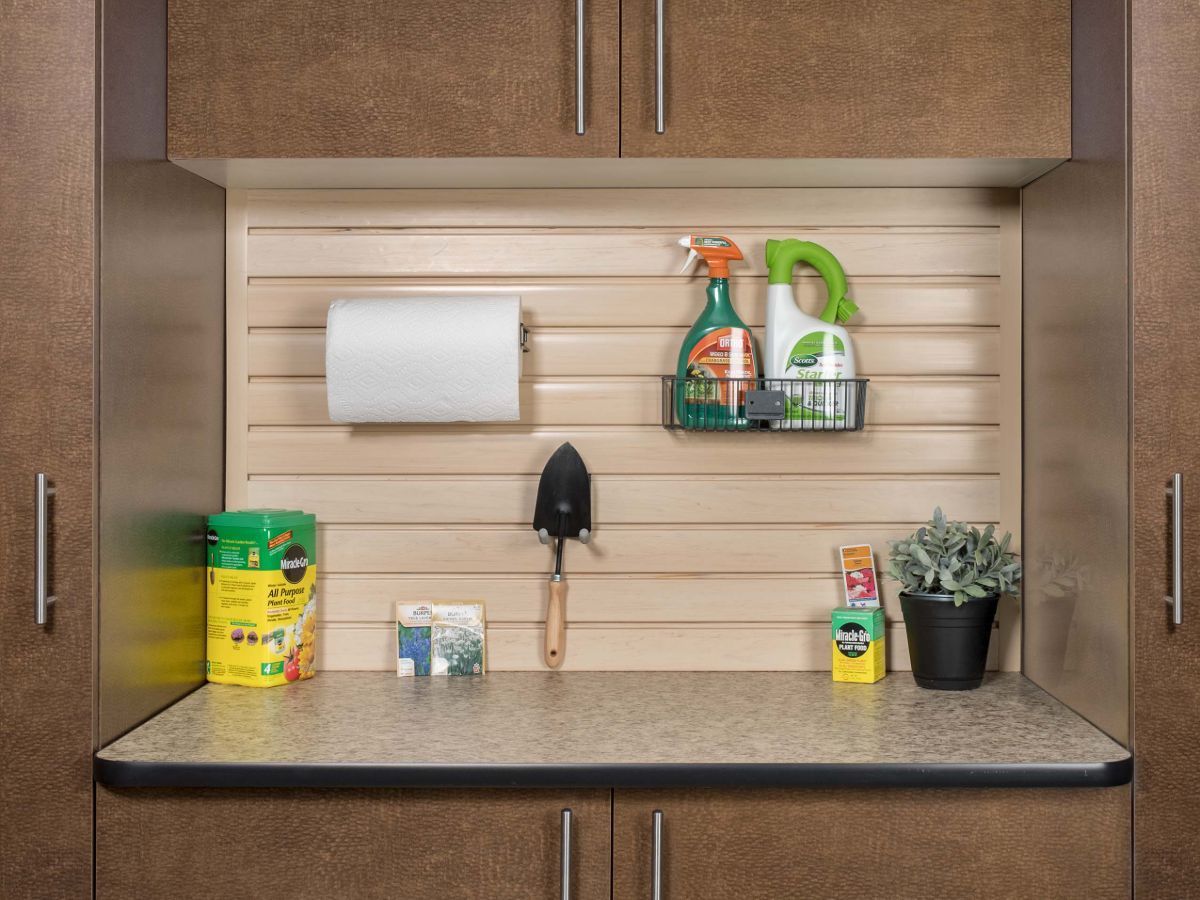 A garage workbenches with cleaning supplies on it.