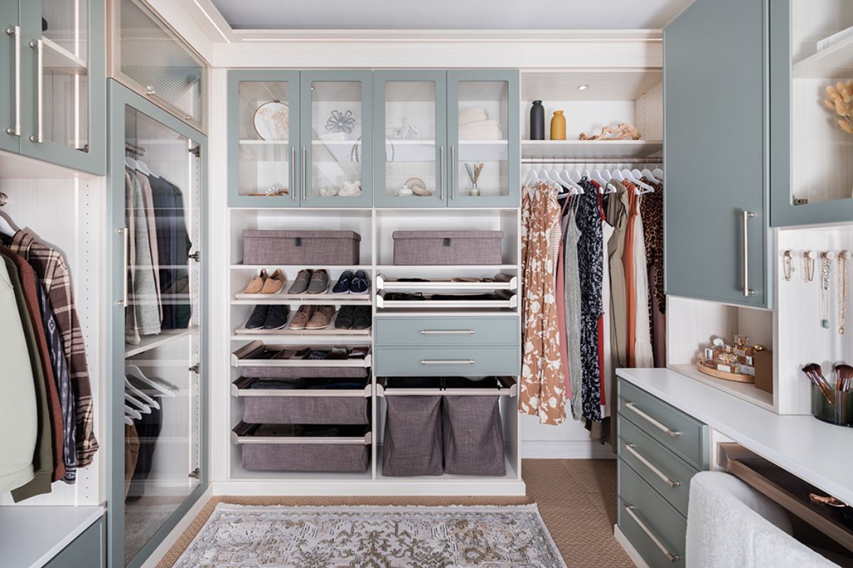 A walk in closet with lots of clothes and drawers.