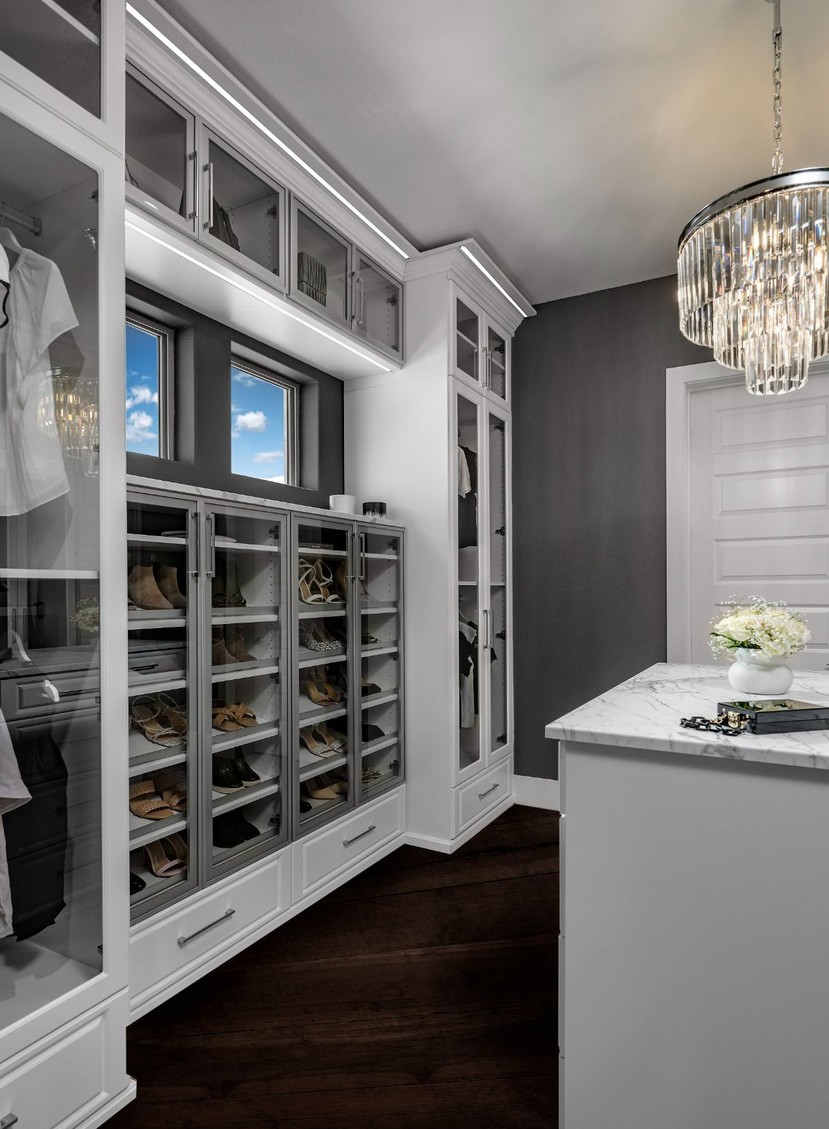 A walk in closet filled with lots of shoes and clothes.