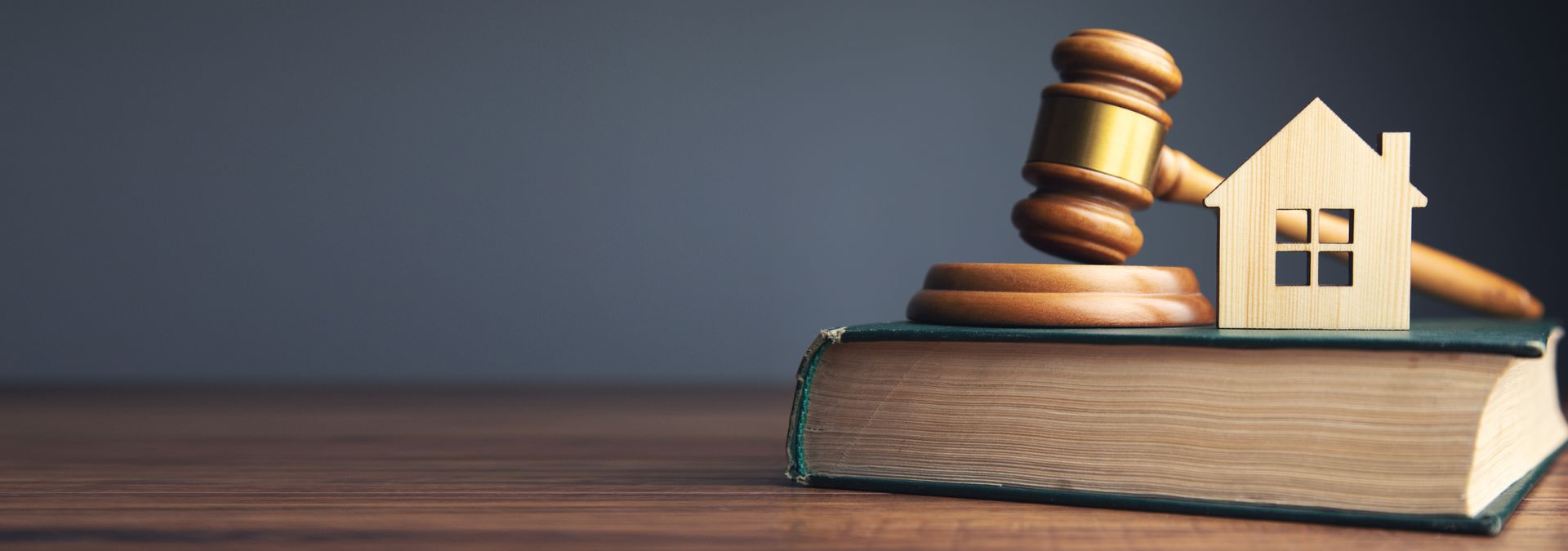 Legal representation for real estate matters illustrated by a gavel and house model.