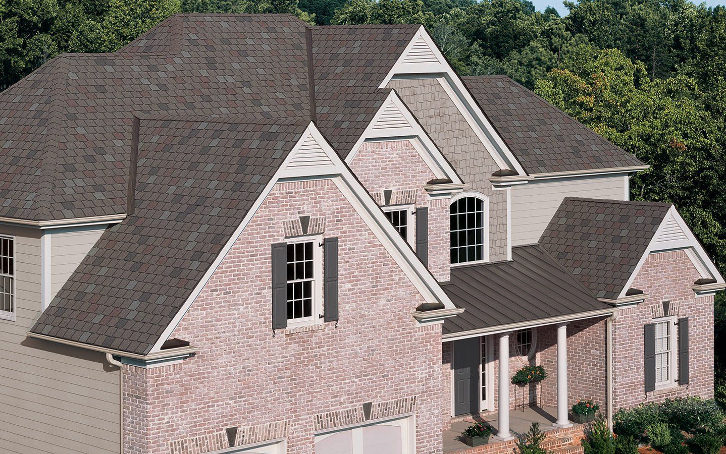 Brick suburban house with gray roof, white trim, and front porch surrounded by trees