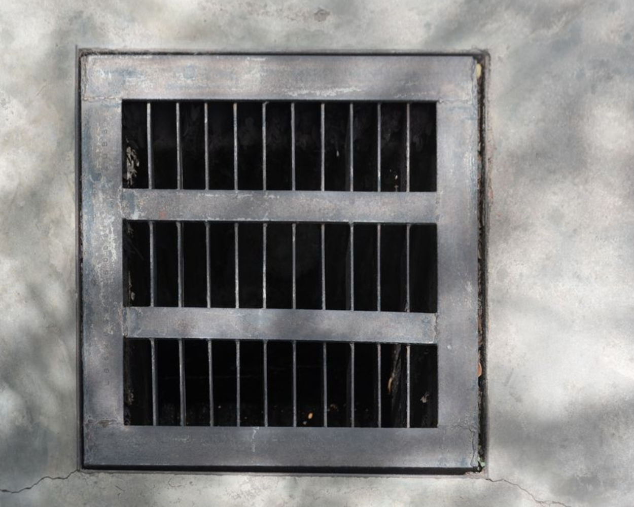 Gray metal ventilation grate with three horizontal slats and vertical bars