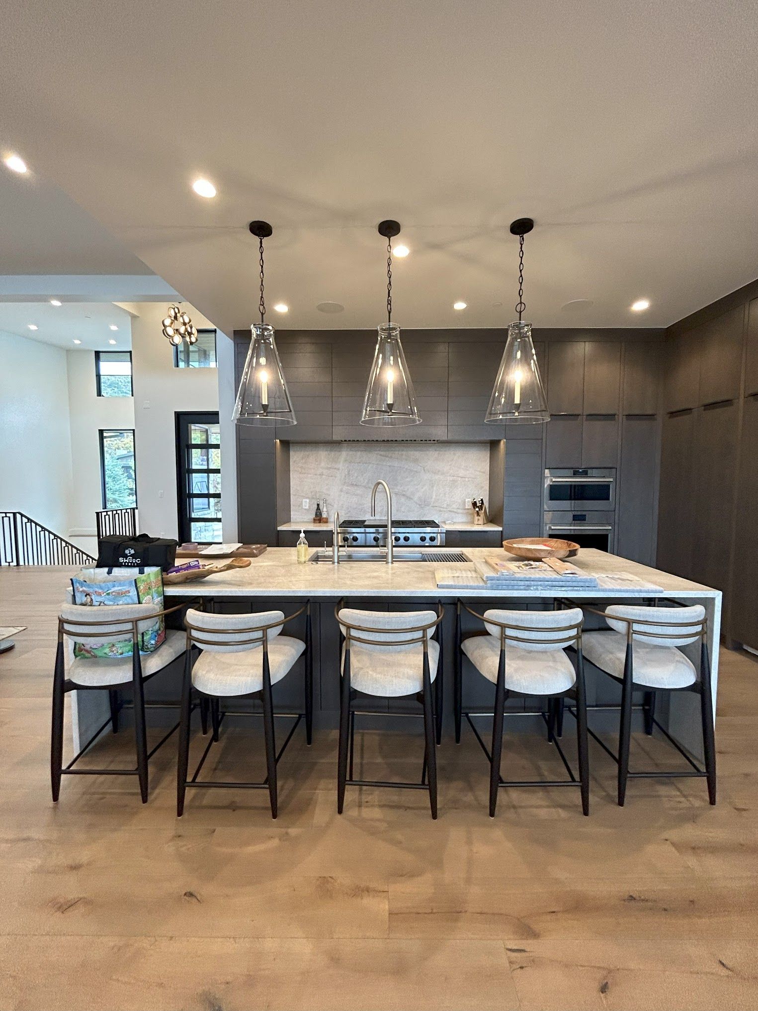 A kitchen with a large island and chairs in it