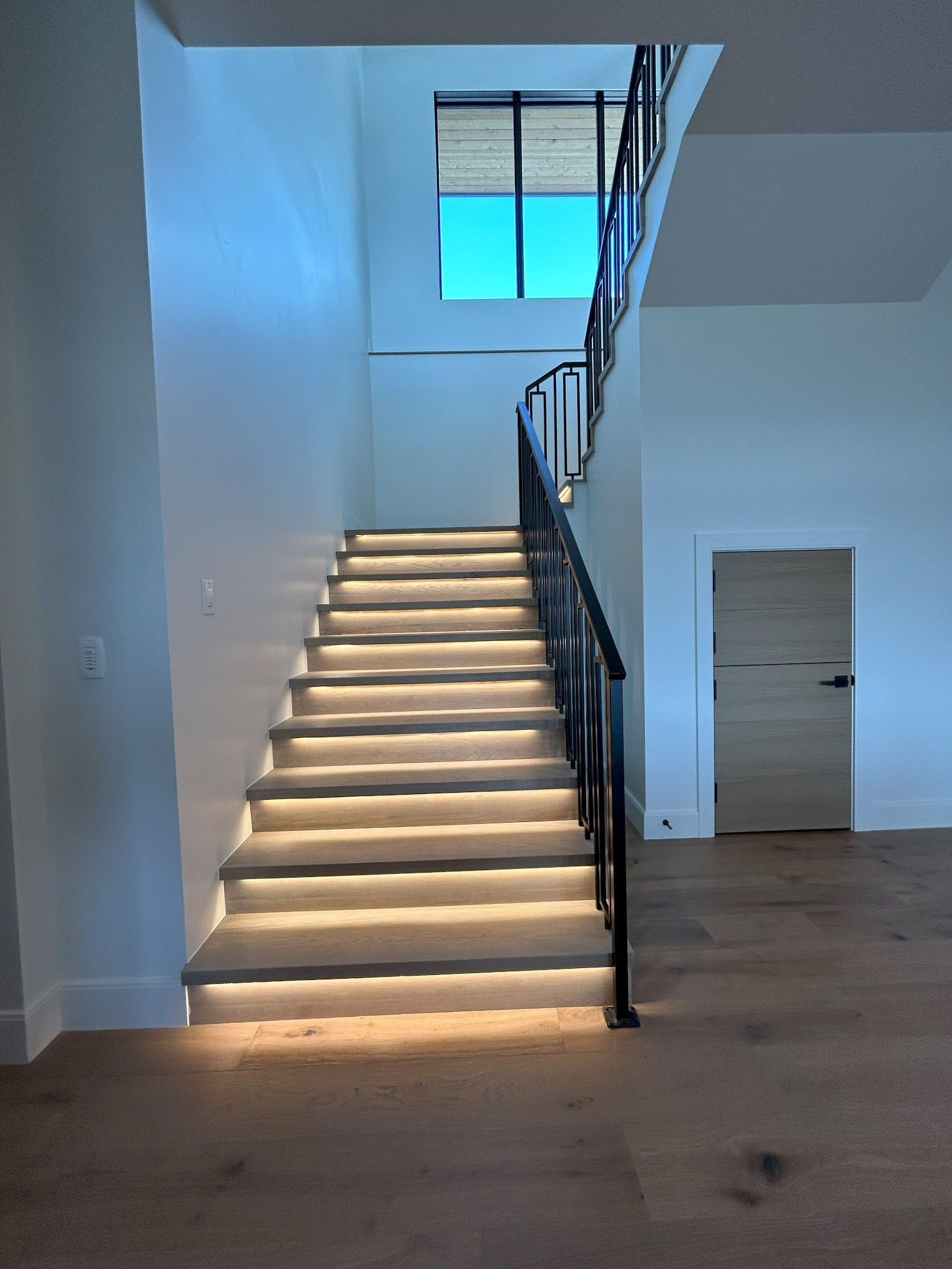 A staircase in a house with lights on the steps