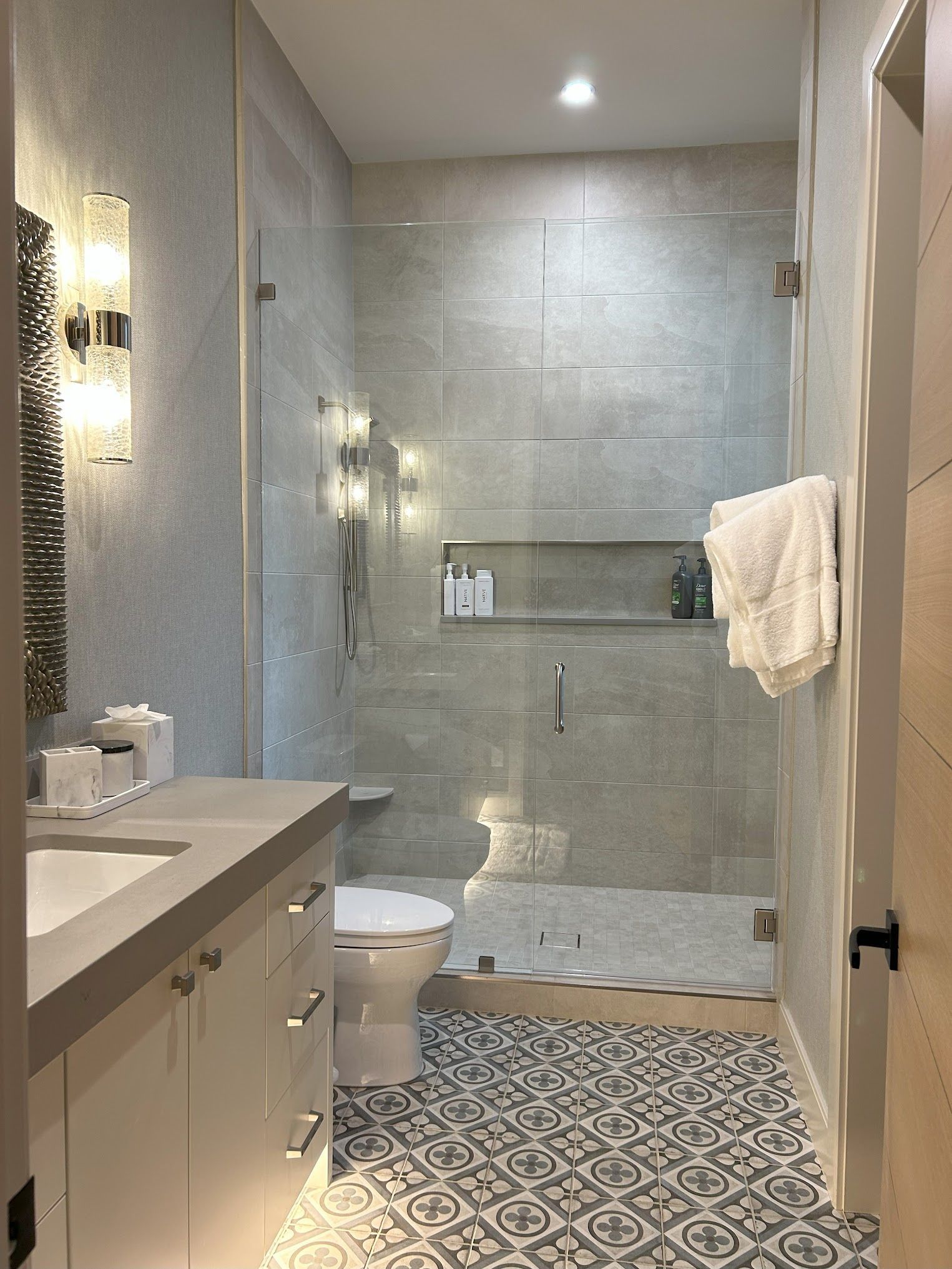 A bathroom with a toilet , sink , and walk in shower.