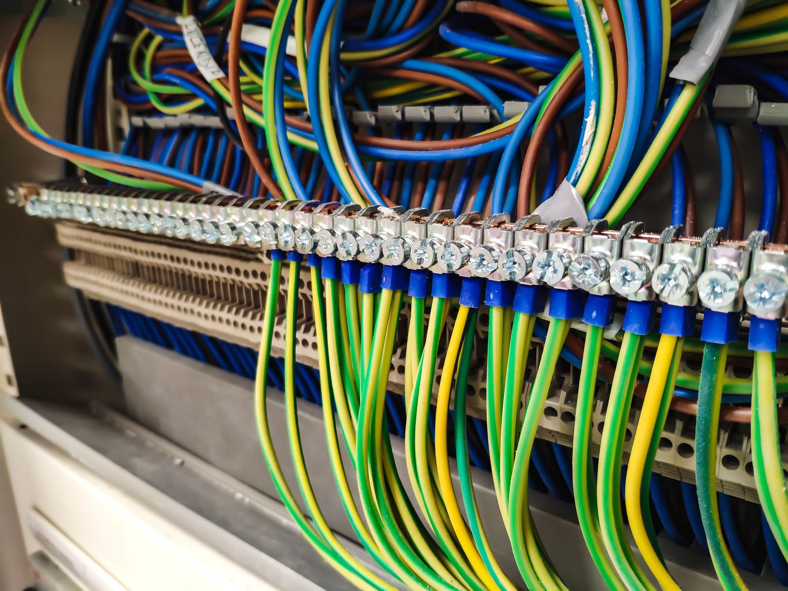 Color-coded electrical wires connected to terminal blocks inside a control panel