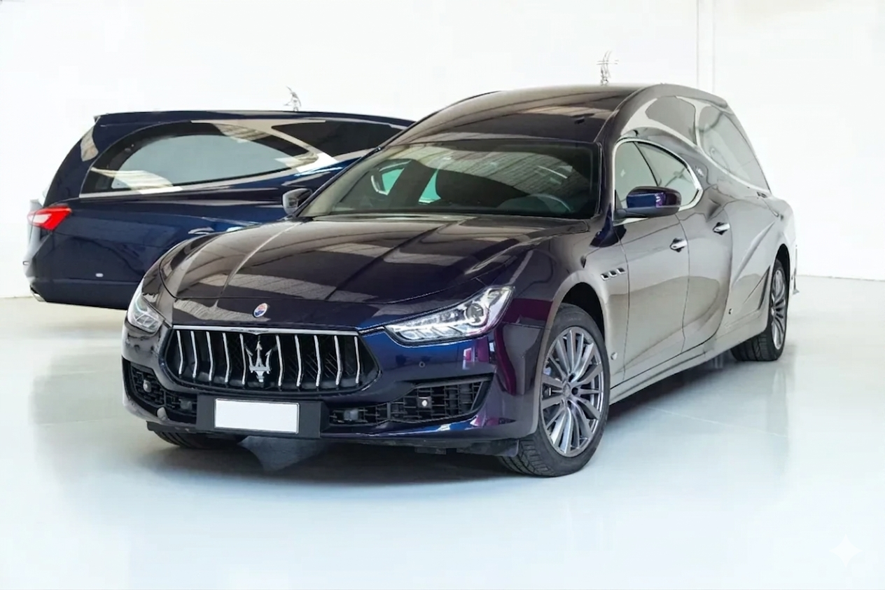 Due berline di lusso blu scuro in uno studio bianco, l'auto anteriore rivolta in avanti