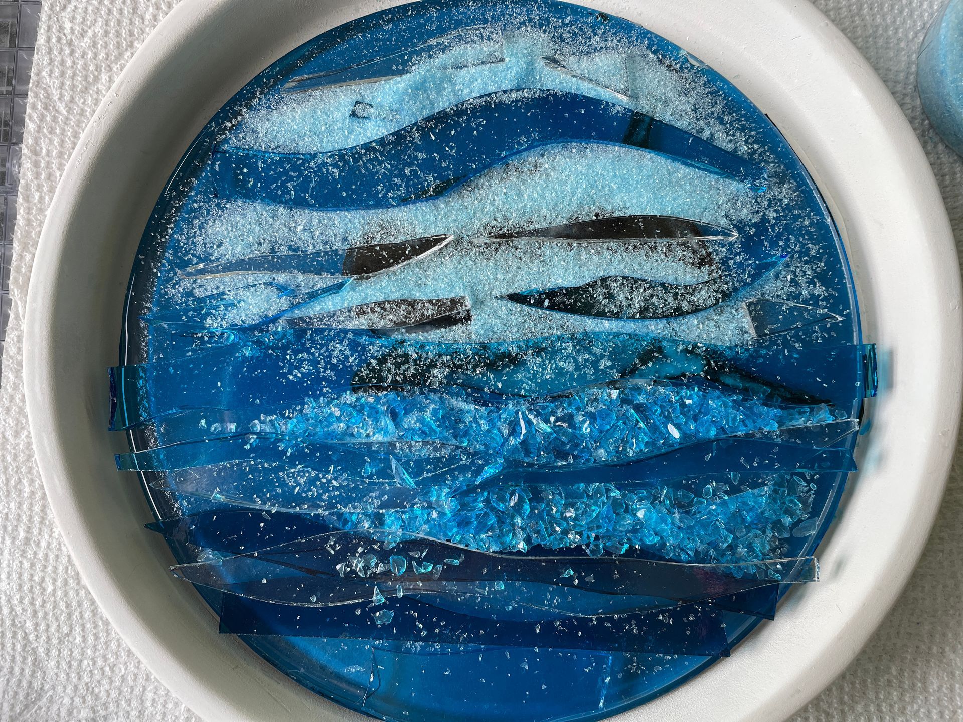 Layers of glass and powder over shark iin kiln
