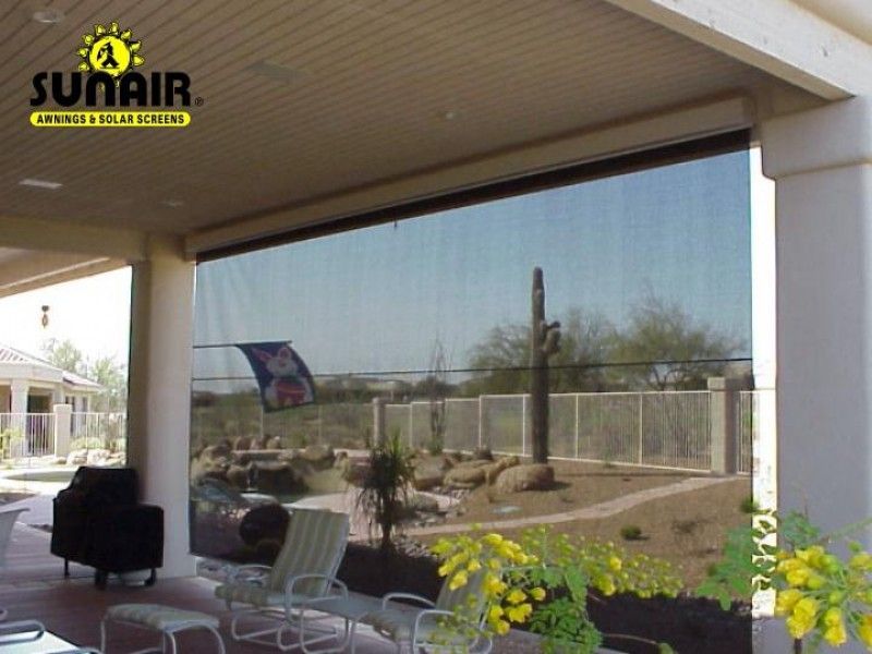 Patio with a large retractable screen overlooking a landscaped yard and fence