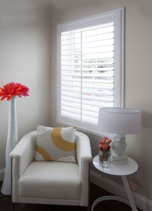 Horizontal white window blinds with a dark, jagged crack or mark running vertically along the adjacent wall.
