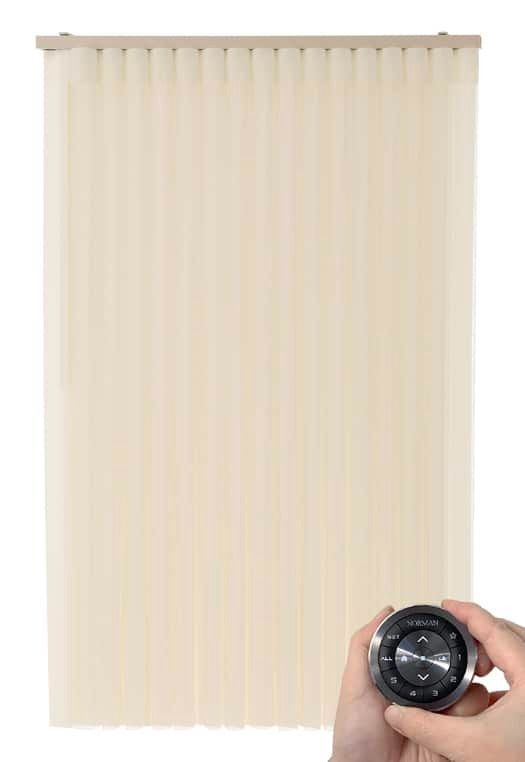 Beige vertical blind panel with a hand holding a small black remote at the lower right.