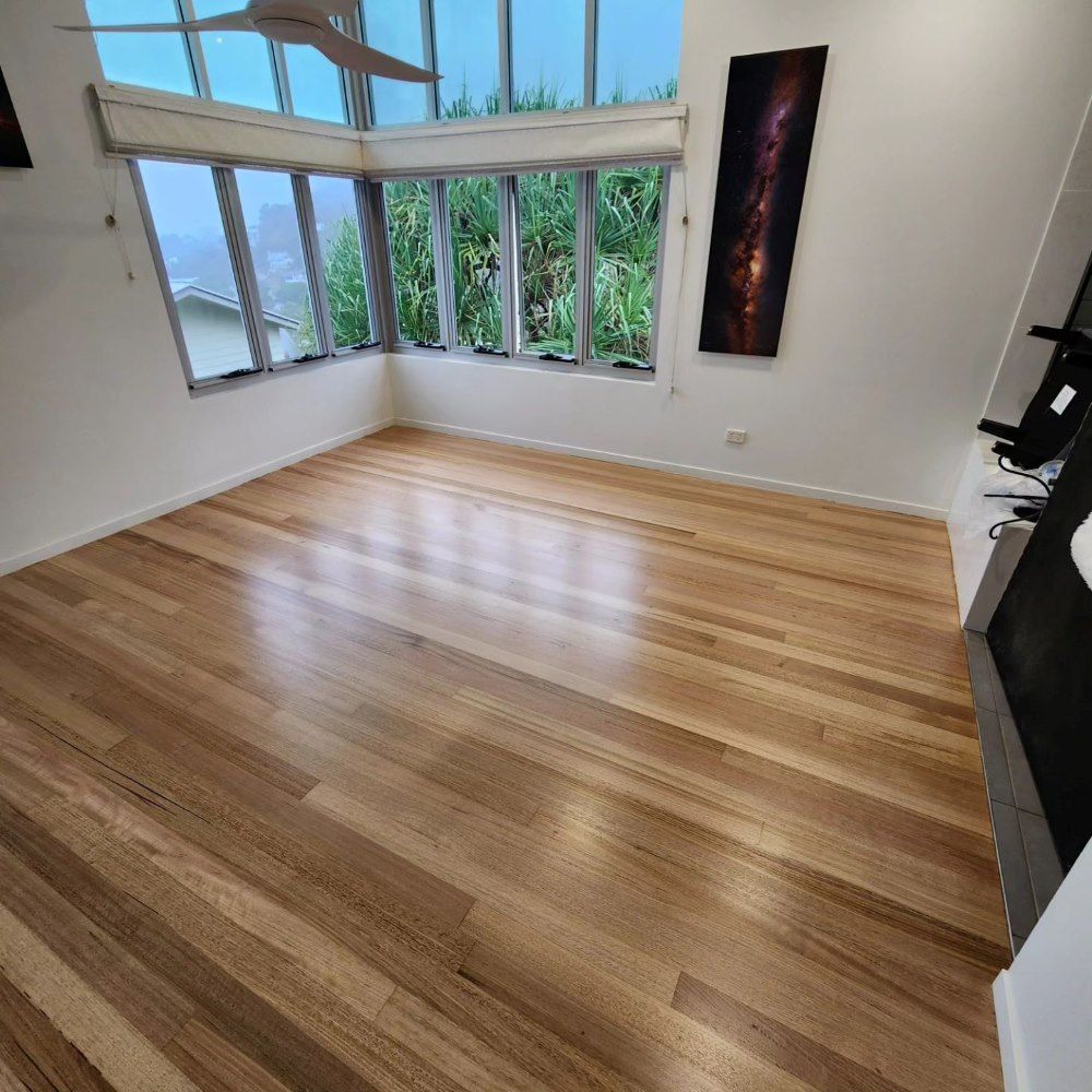 A Living Room With Hardwood Floors and a Ceiling Fan — ATM Floors In Mount Louisa, QLD