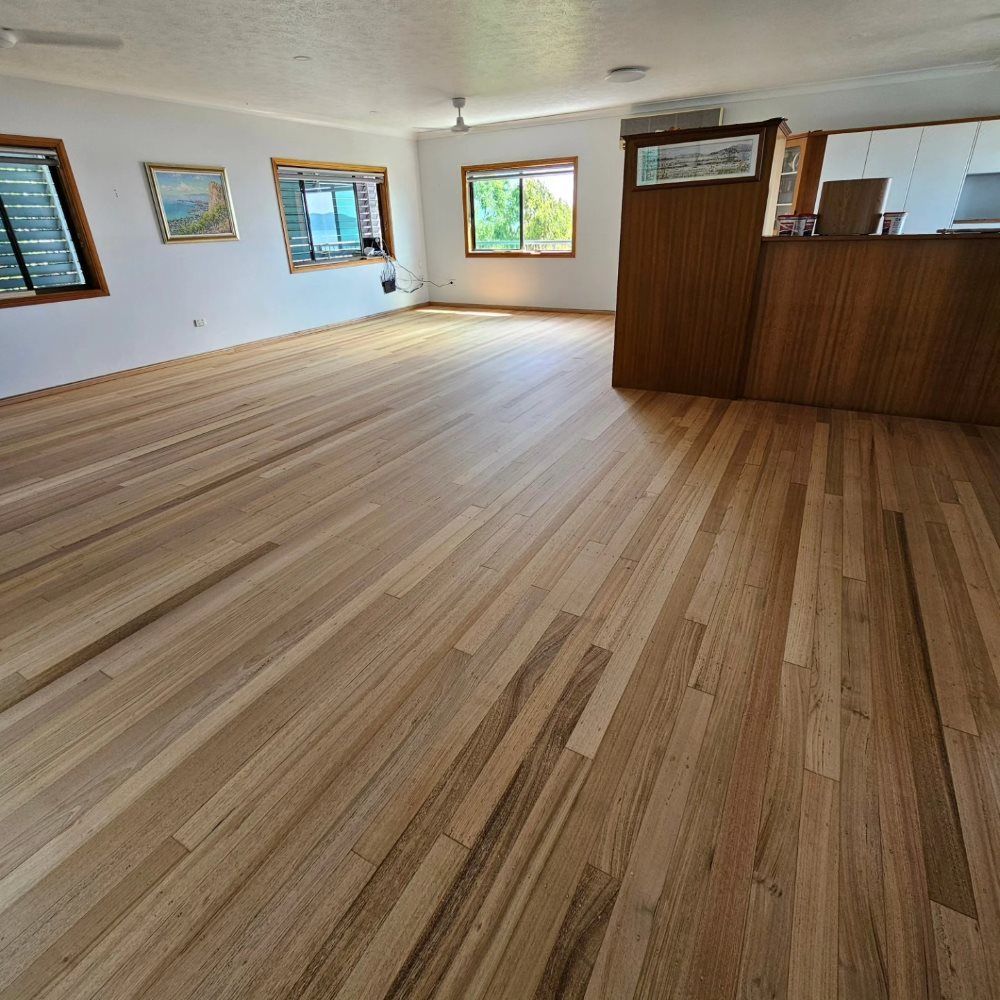 A Large Room With a Wooden Floor and Lots of Windows — ATM Floors In Mount Louisa, QLD