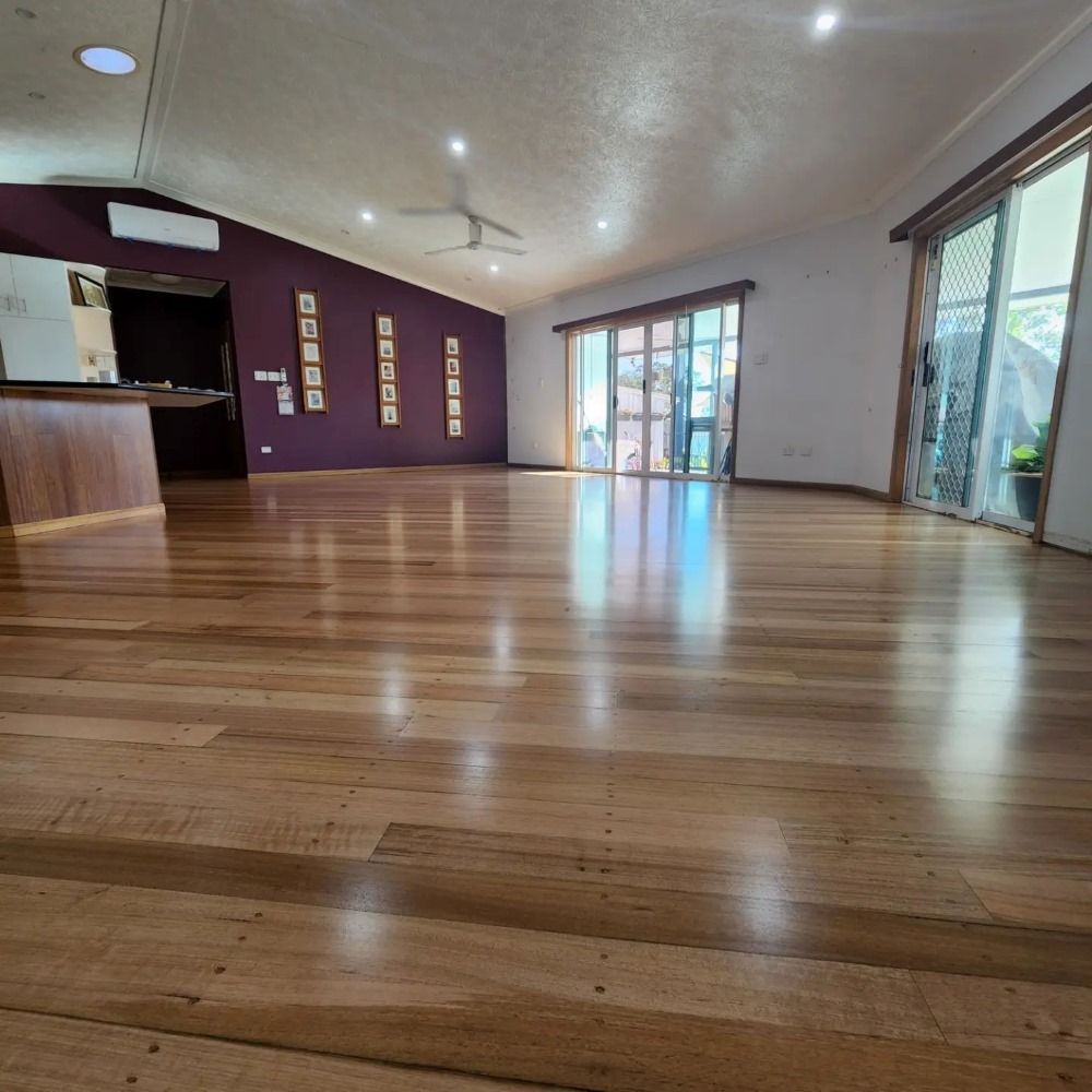 A Large Room With Hardwood Floors and Purple Walls — ATM Floors In Mount Louisa, QLD