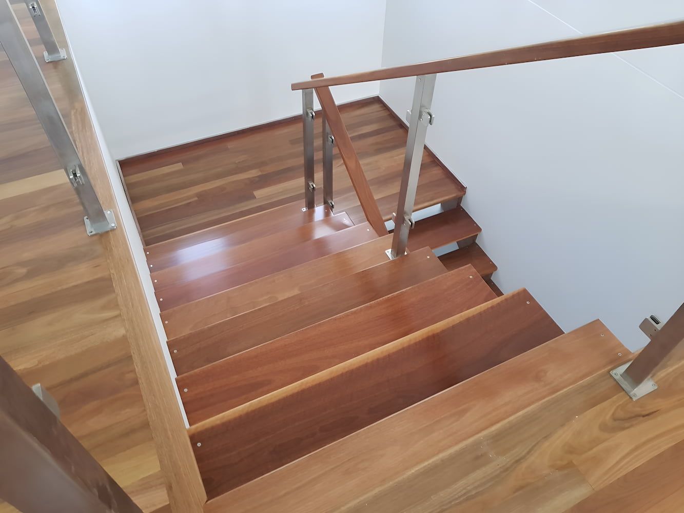 A Wooden Deck With A Swimming Pool In The Background — ATM Floors In Mount Louisa, QLD A Wooden Deck With a Wire Railing and a Screen Door — ATM Floors In Mount Louisa, QLD