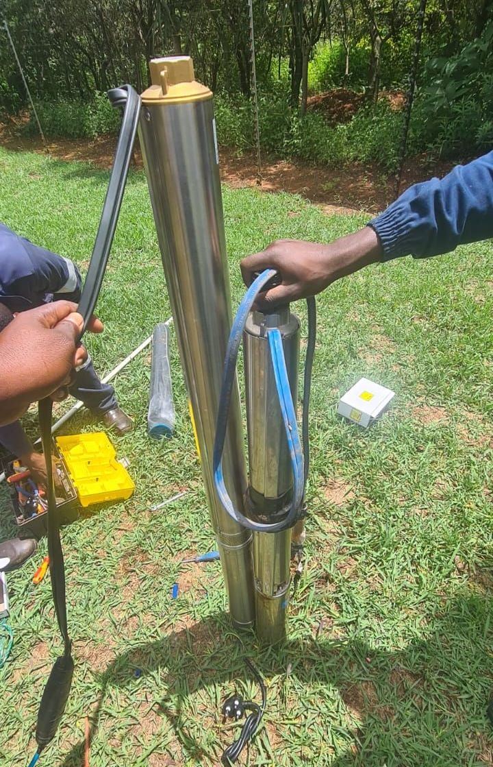 A man in an orange vest is working on a pipe