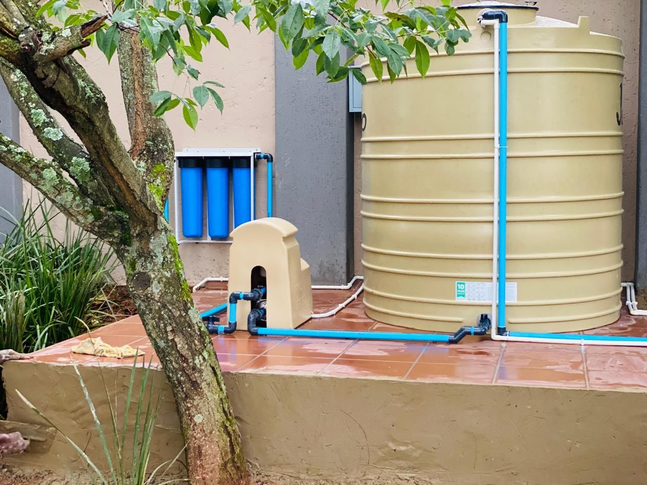 A large water tank with blue pipes attached to it.