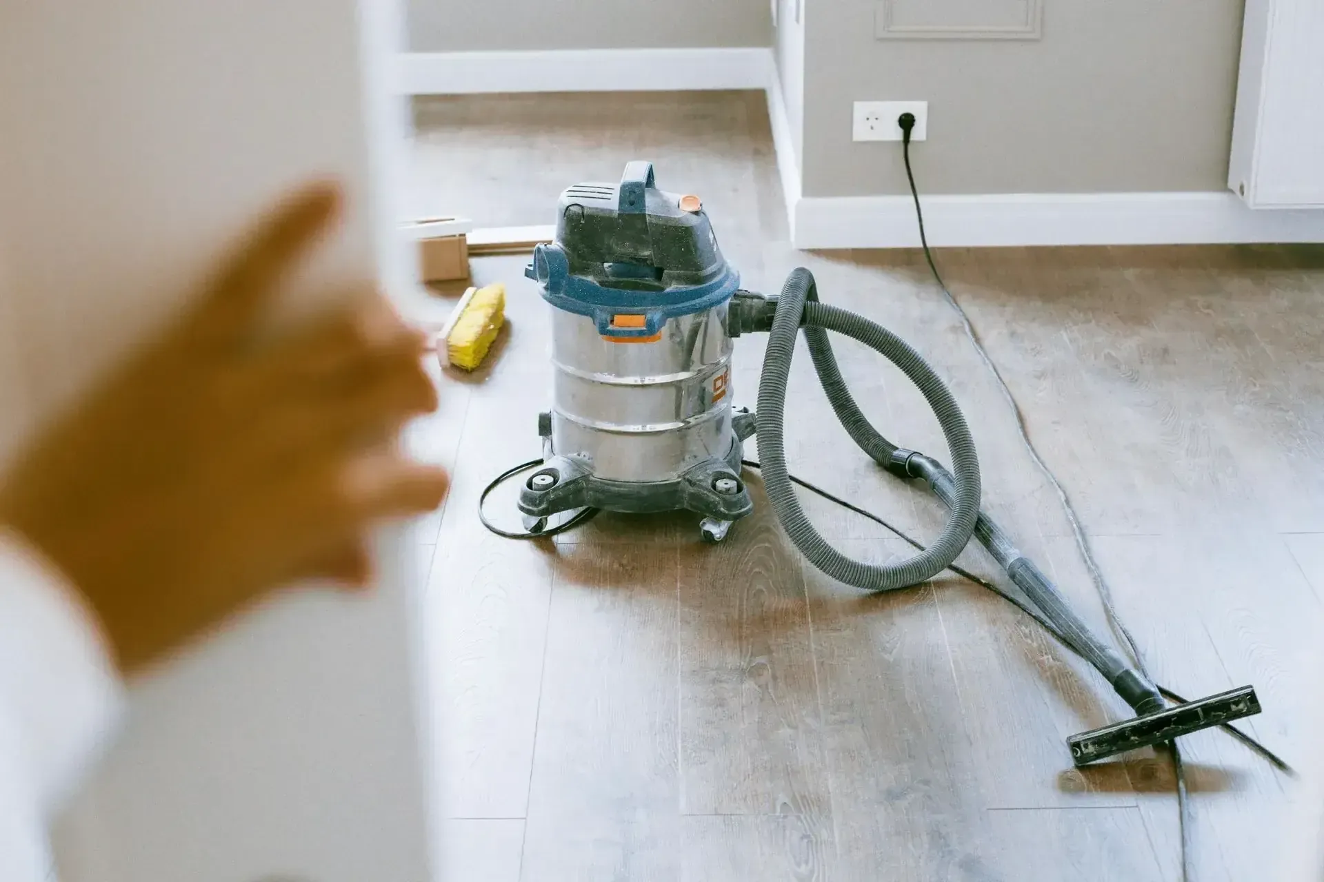 Wet/dry vacuum cleaner on hardwood floor.