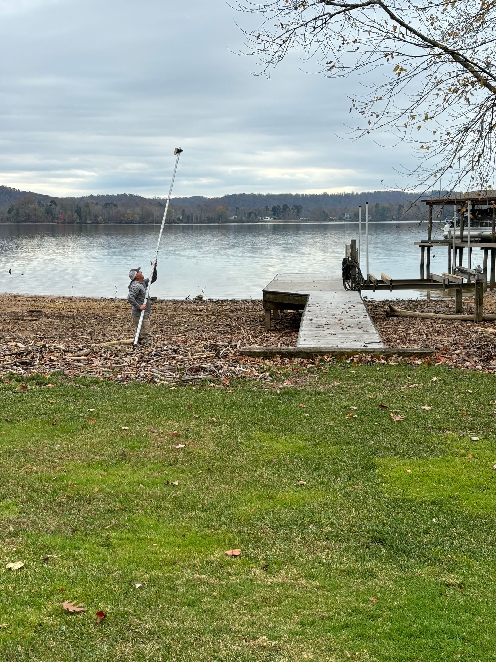 A person is taking a picture of a lake with a camera.