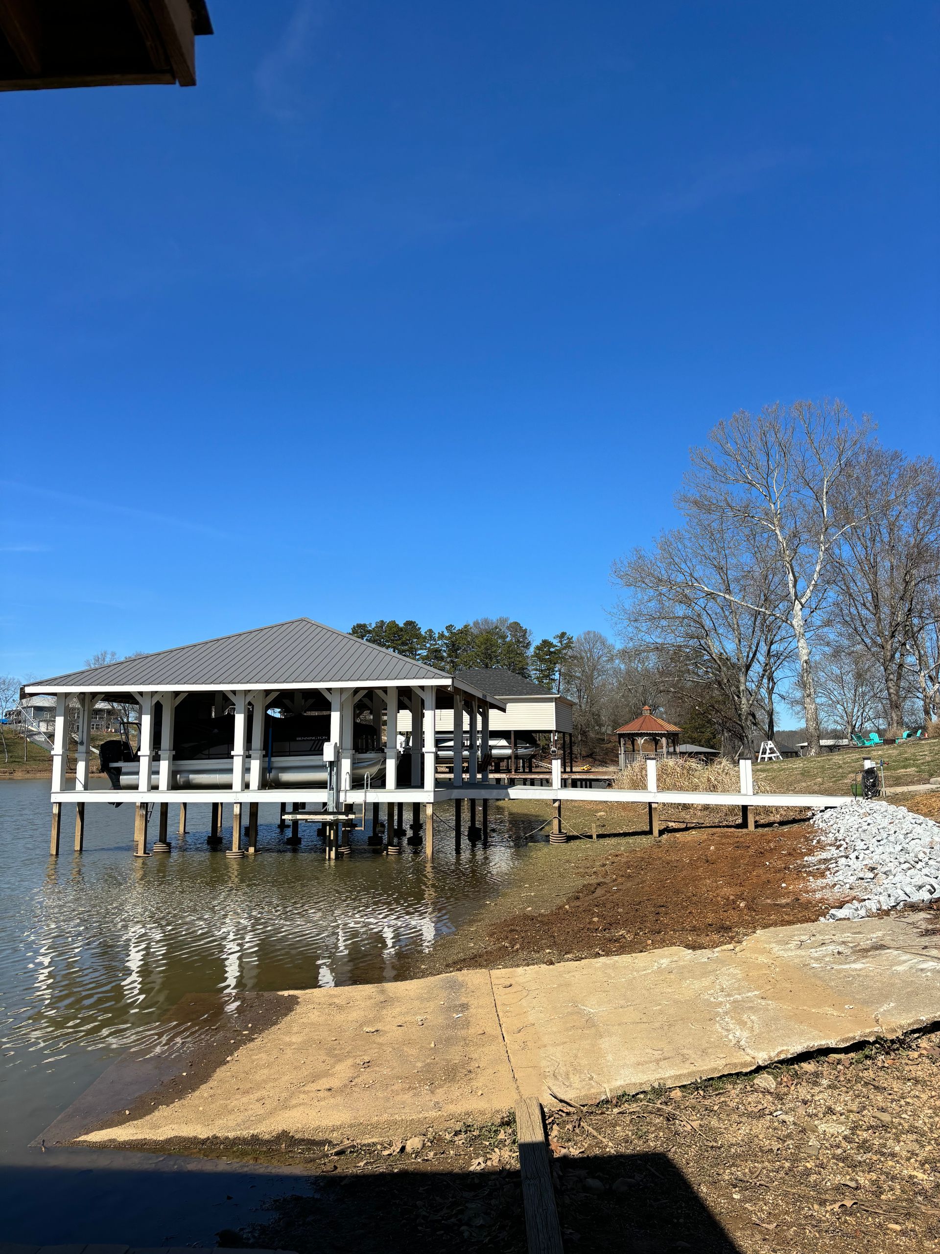 A boat house is sitting on top of a body of water.