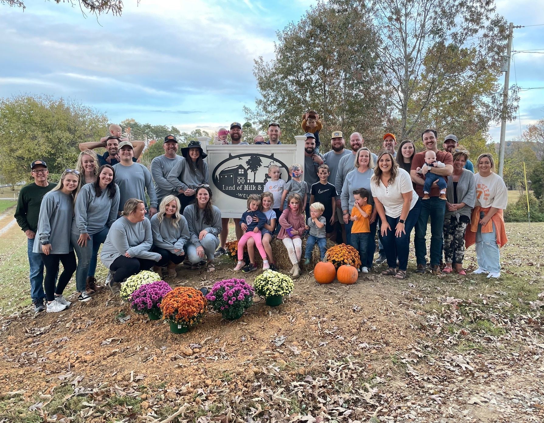A large group of people are posing for a picture in front of a sign.