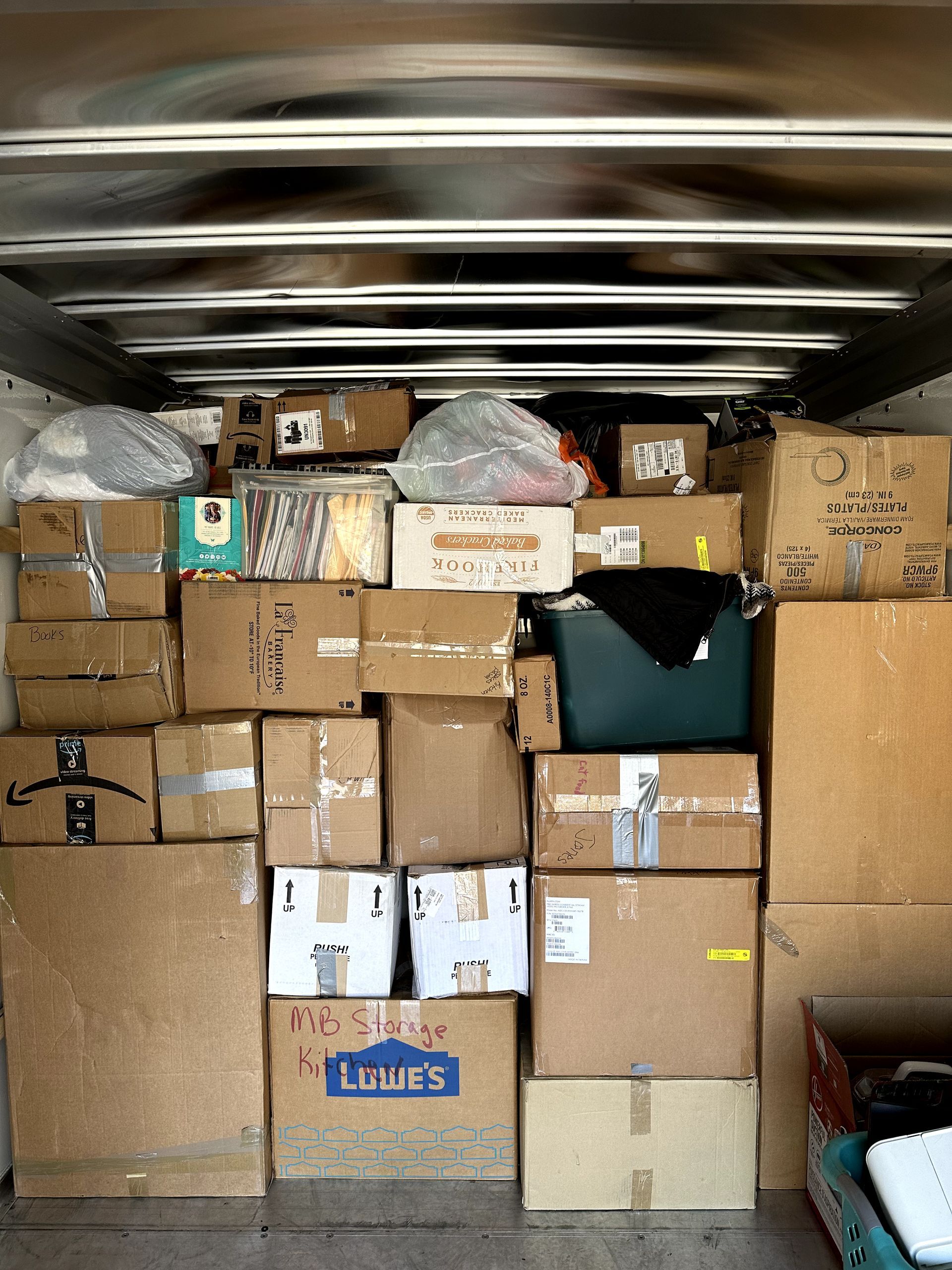 A lot of boxes are stacked on top of each other including one that says laura 's
