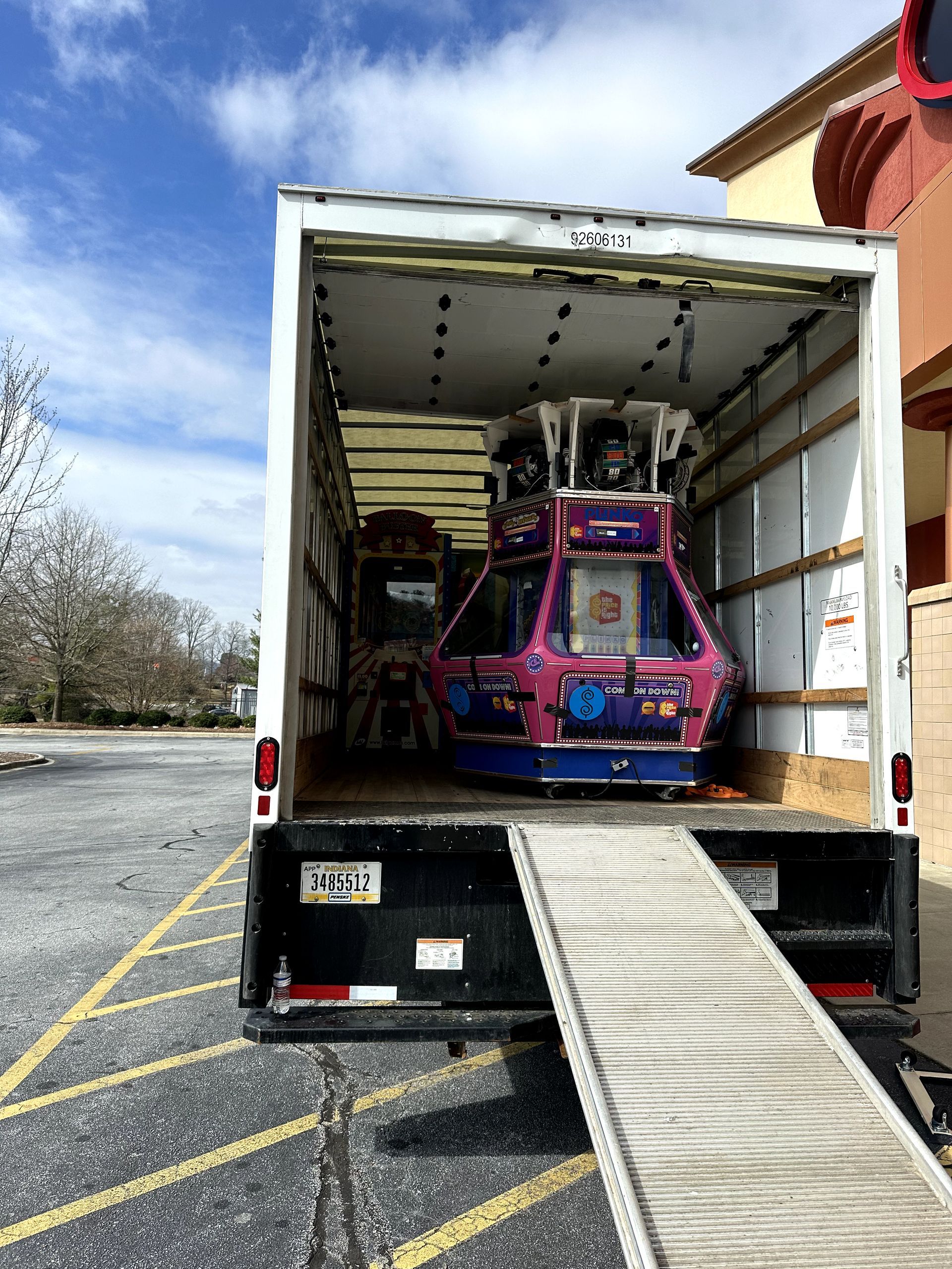 A truck is loaded with a ferris wheel in a parking lot.