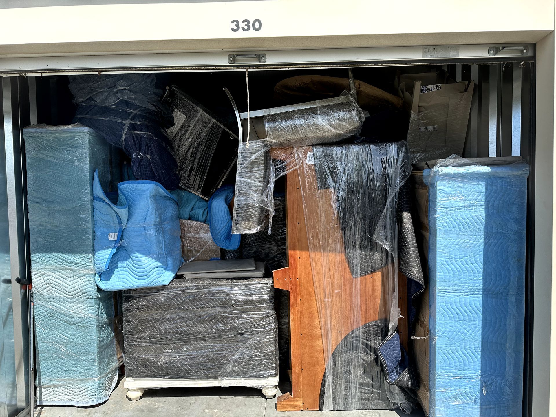 A storage unit filled with lots of moving boxes and furniture.
