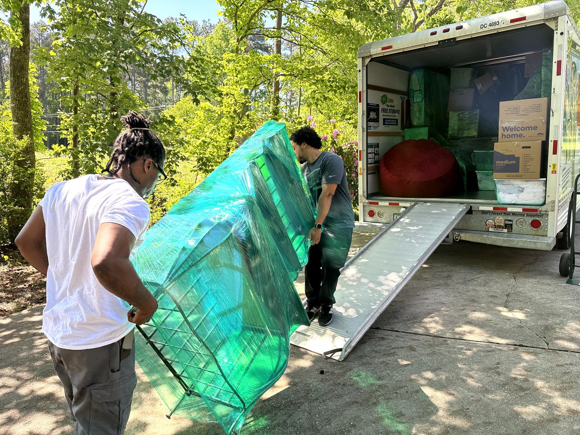 Two men are loading a couch into a moving truck.