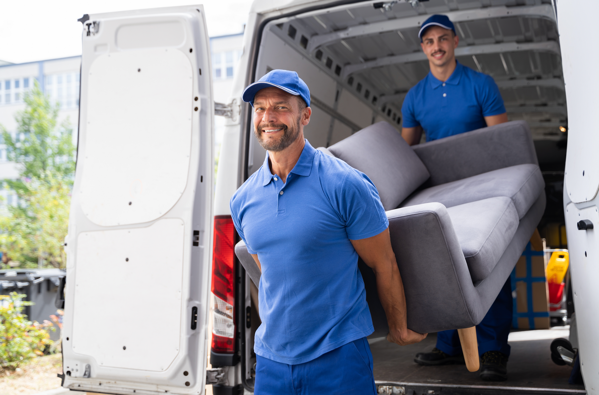 A man is holding a cardboard box in front of a group of moving boxes.