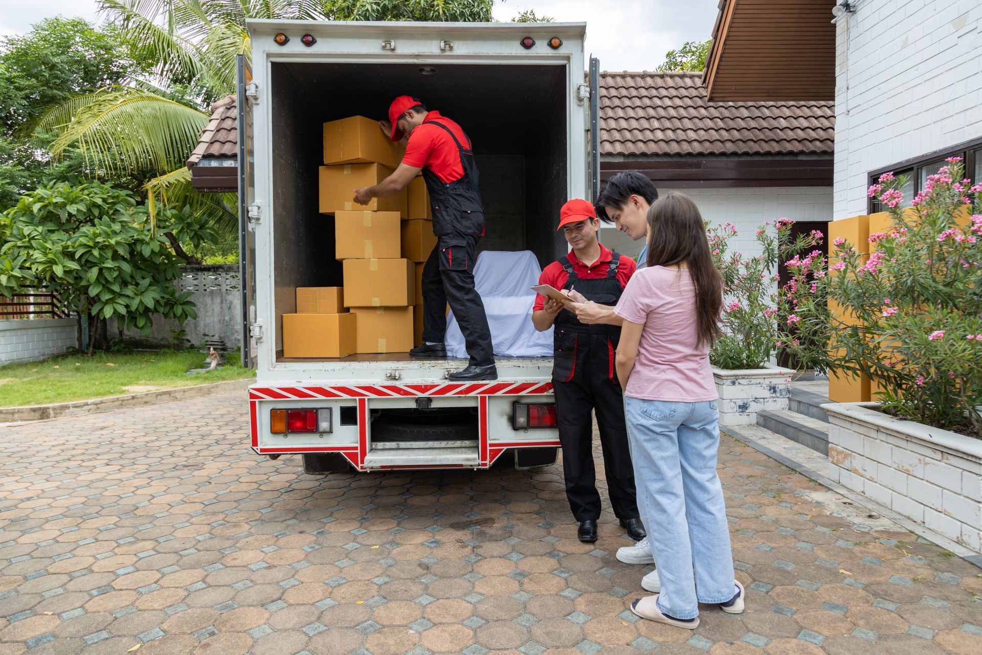 A group of people are standing in front of a moving truck.