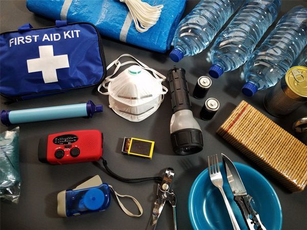 A first aid kit is surrounded by water bottles and other items