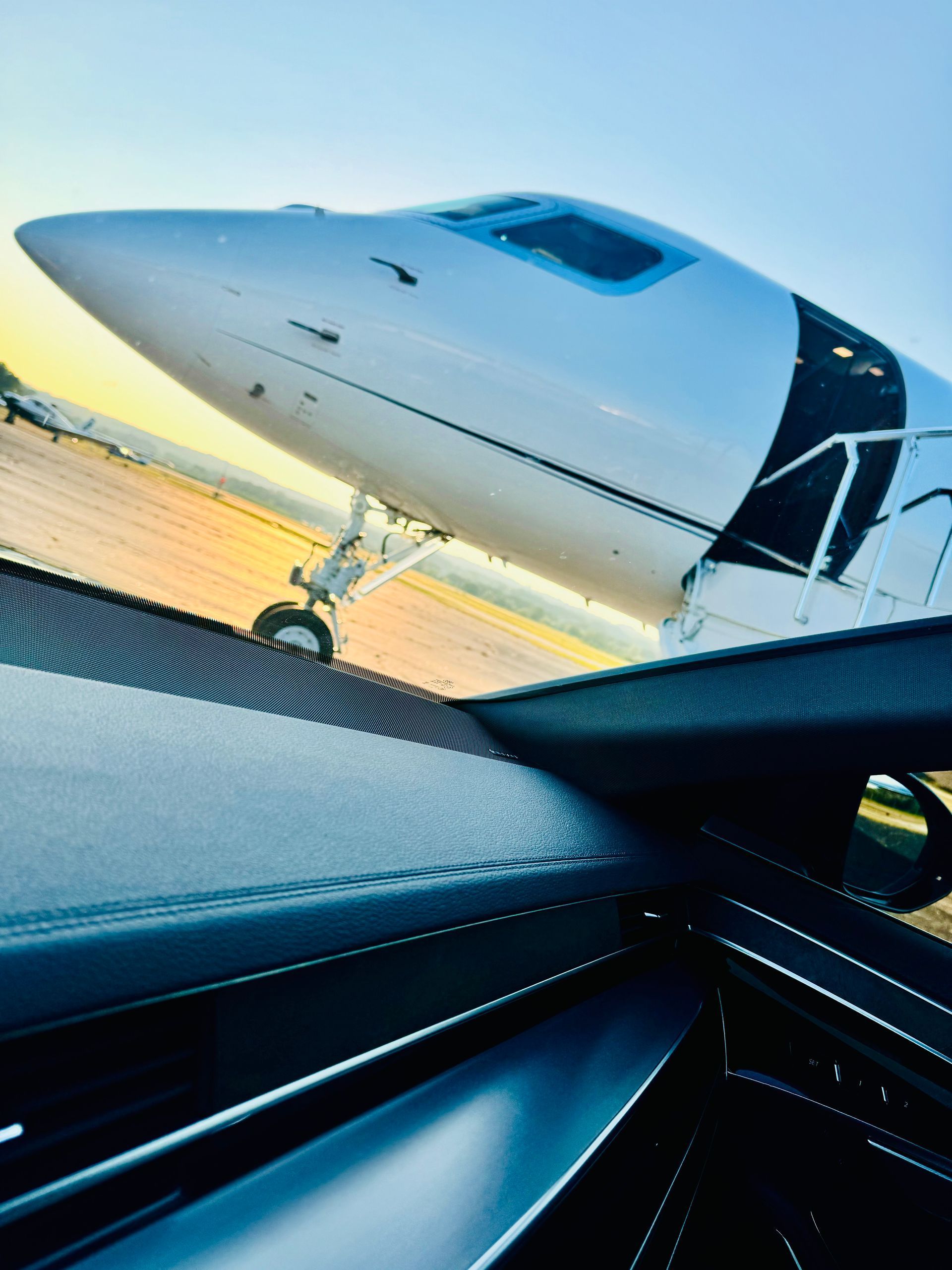 A plane is parked on a runway next to a car