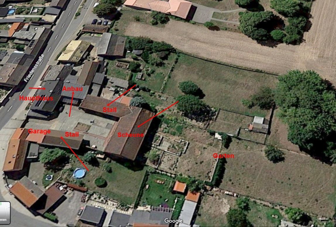 Luftaufnahme einer ländlichen Gegend mit Häusern, Straßen, Feldern und roten Etiketten, die die Grundstücke kennzeichnen.