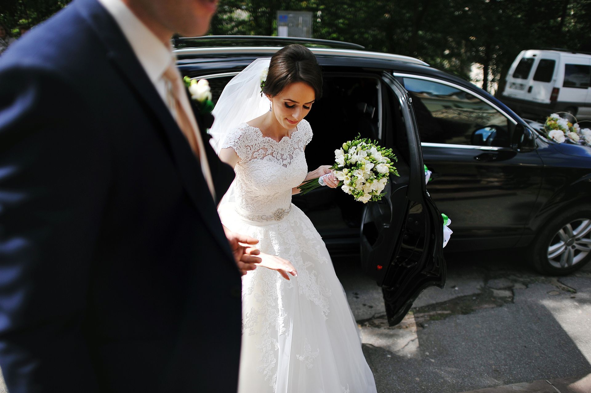 Una sposa e uno sposo stanno scendendo da un'auto.