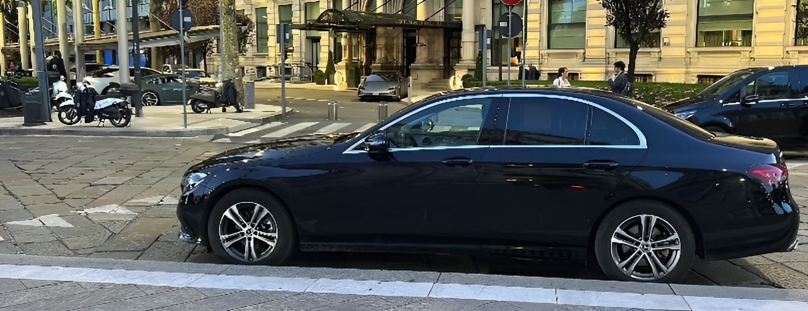 Un'auto nera è parcheggiata sul ciglio della strada.