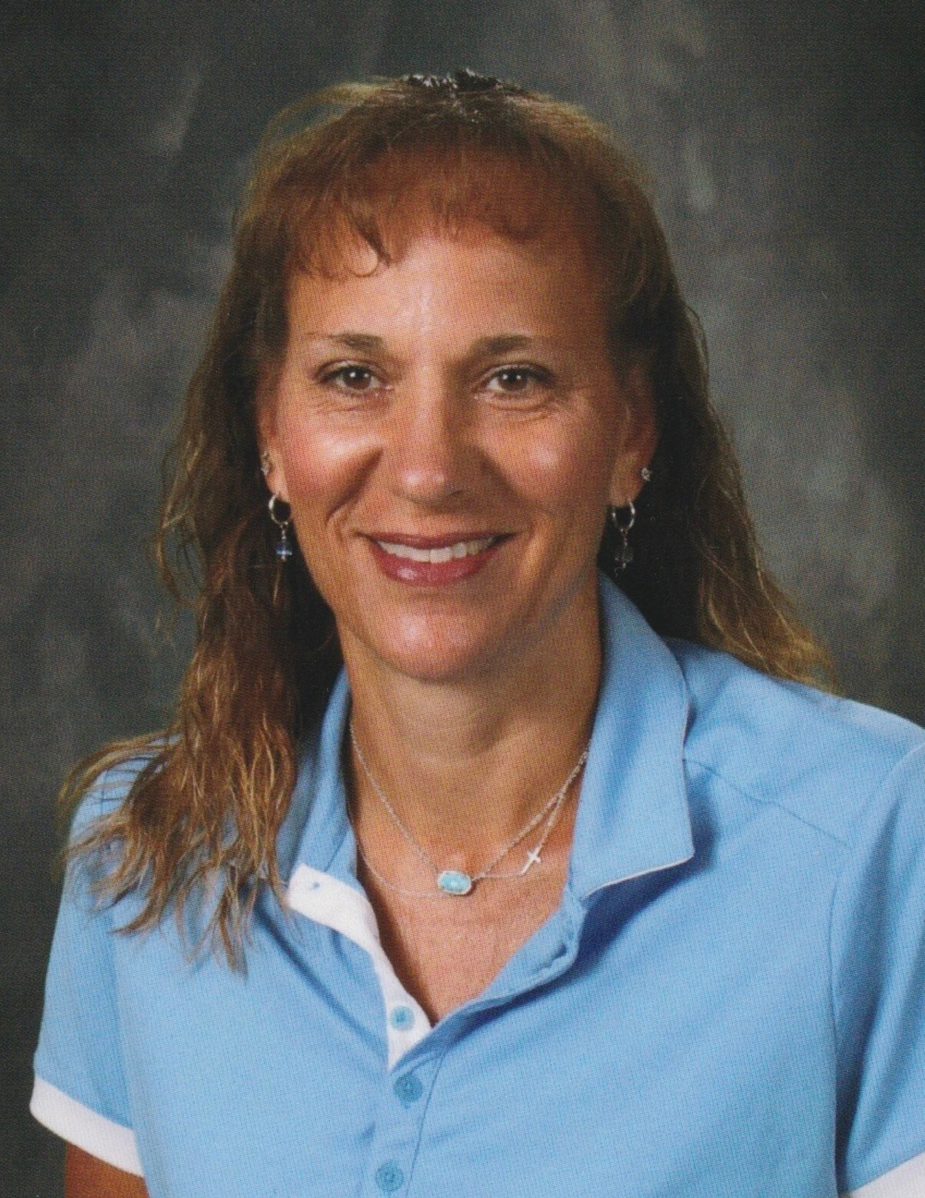 A close up of a woman 's face with long hair and a blue shirt.
