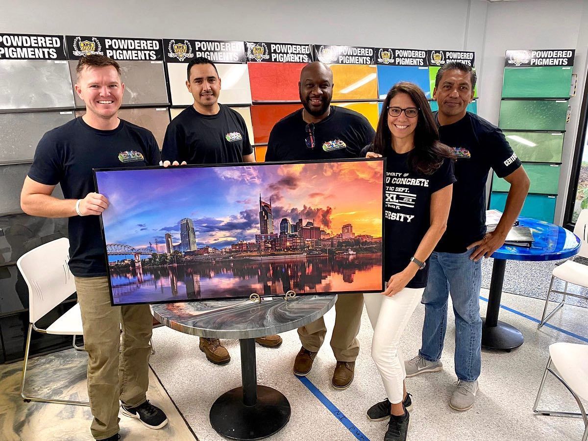 Five people holding a large cityscape print in a bright office with posters on the wall
