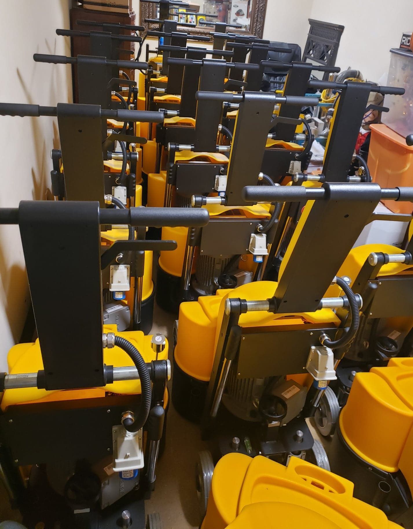 Rows of yellow and black industrial machines lined up in a storage or workshop area.