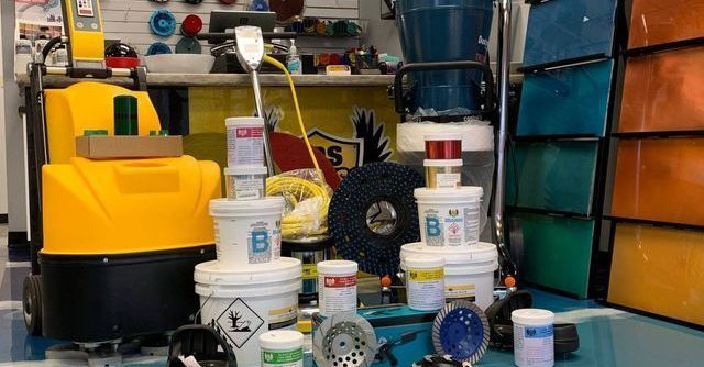 Shelves of pool supplies and cleaning products in a store, with yellow and white containers and blue filters.