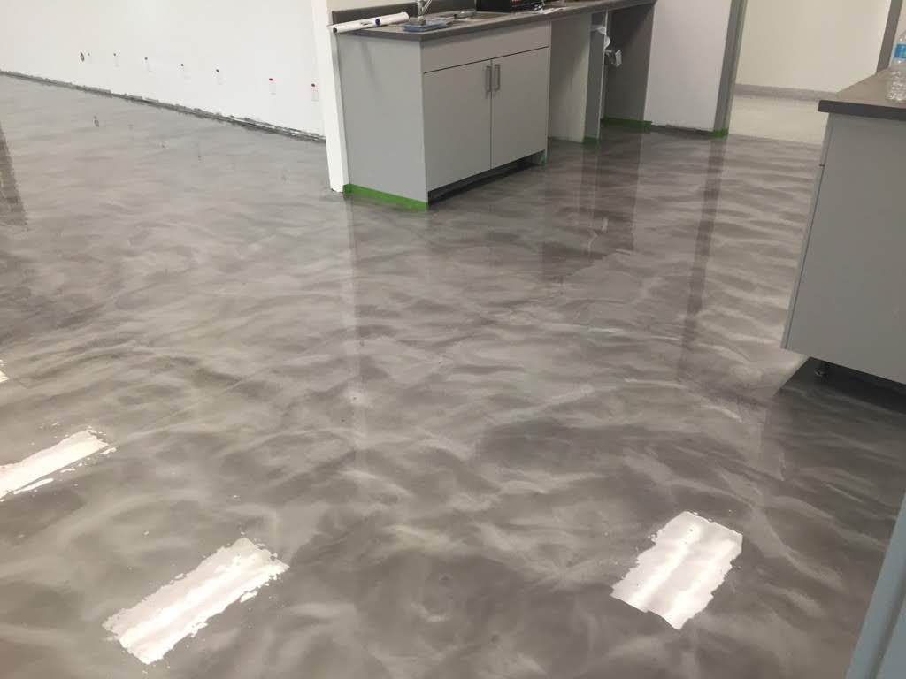 Empty office with glossy gray floor and cabinets along the wall.