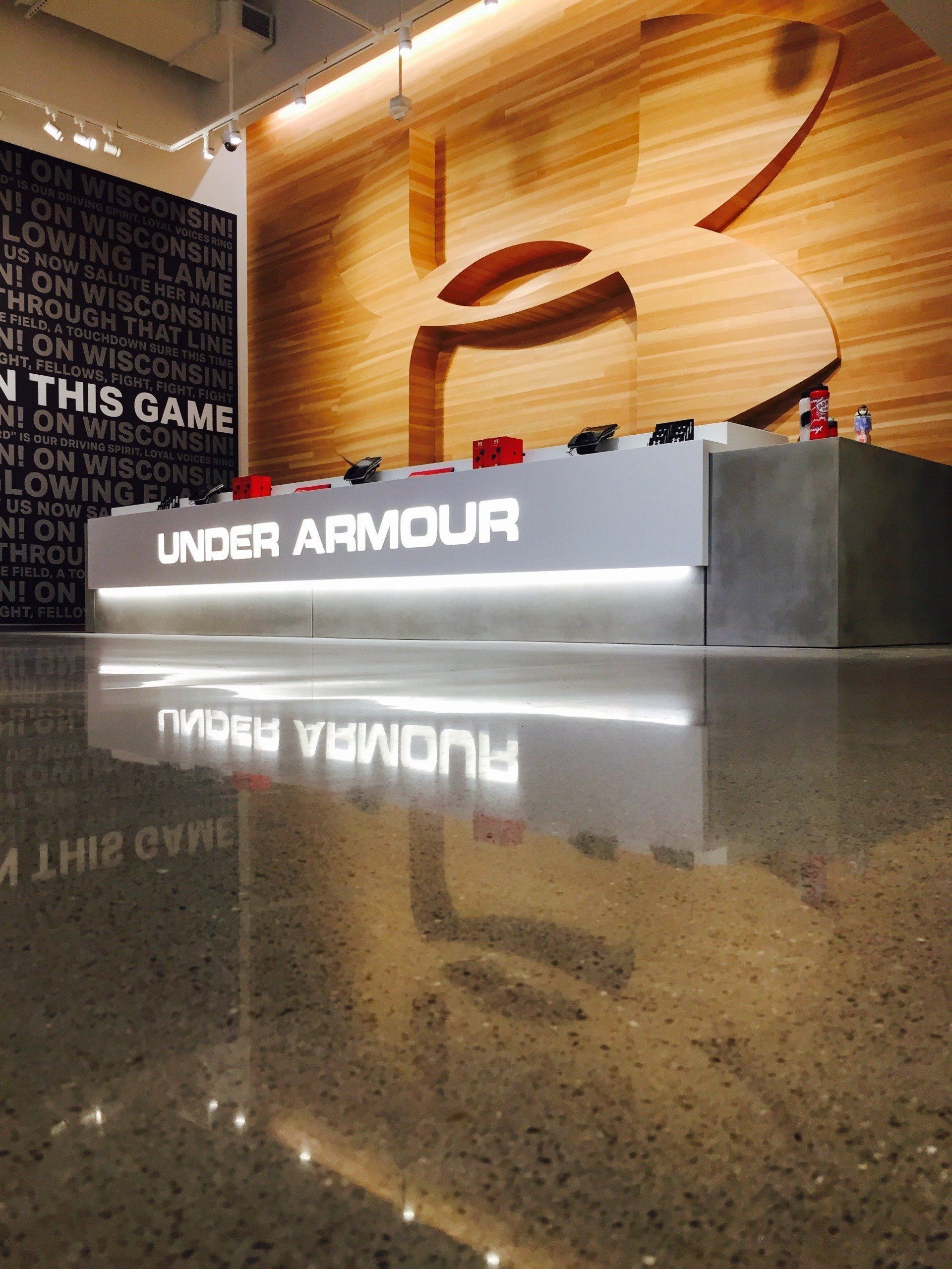 Under Armour store display with illuminated logo reflected on a polished floor