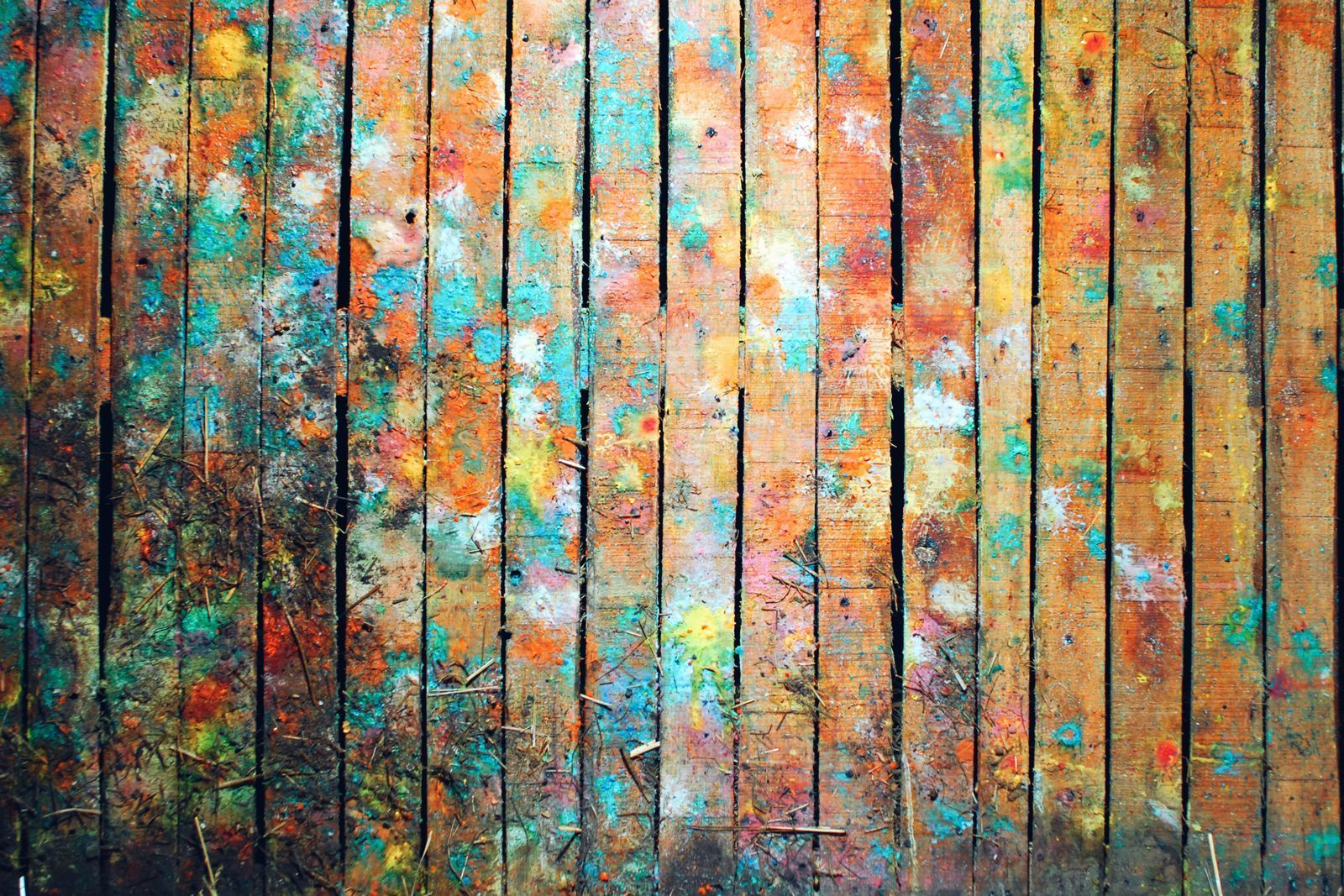 Abstract textured wall with vertical black lines and splashes of orange, turquoise, and white paint