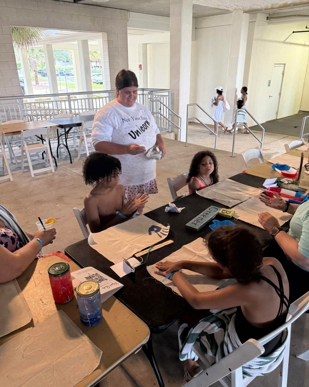 People gathered around tables crafting with supplies in a bright open room