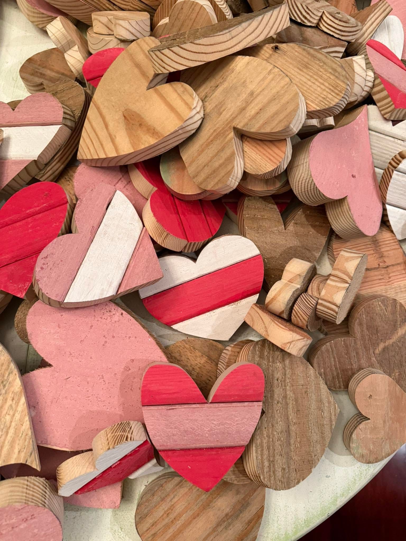 Pile of wooden heart-shaped confetti in red, pink, and natural wood tones