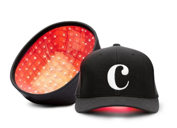 Black cap with white "C" logo and a red LED light therapy cap open beside it.