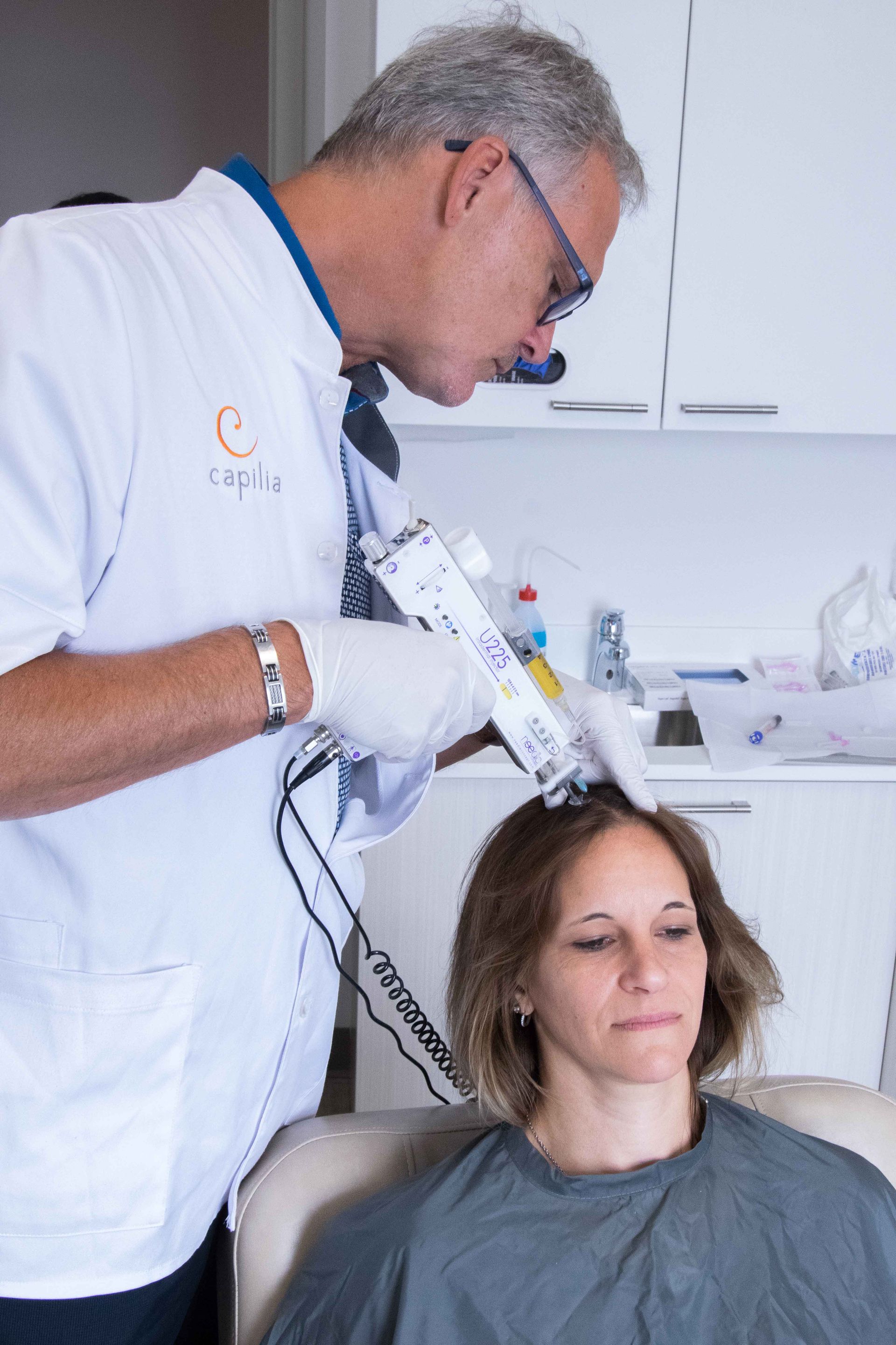 Dentist using a syringe on a woman seated in a dental chair