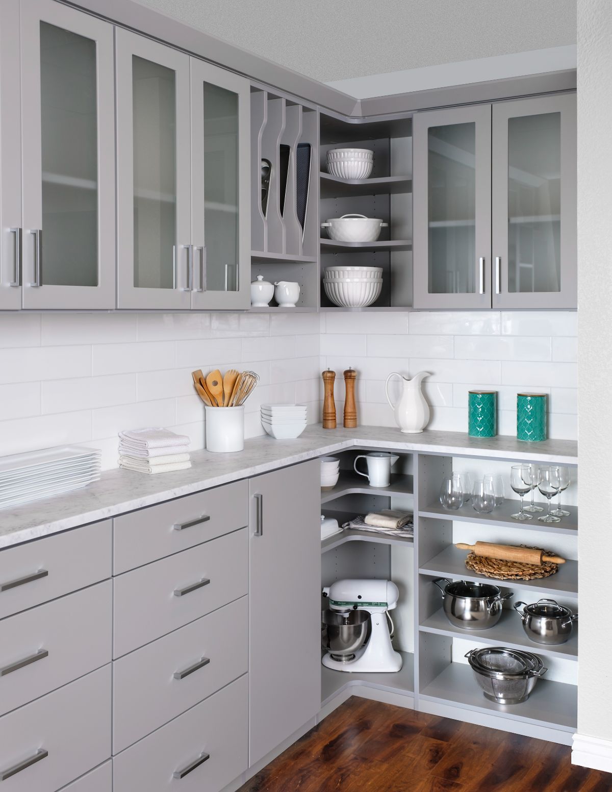 A kitchen with gray cabinets and glass doors